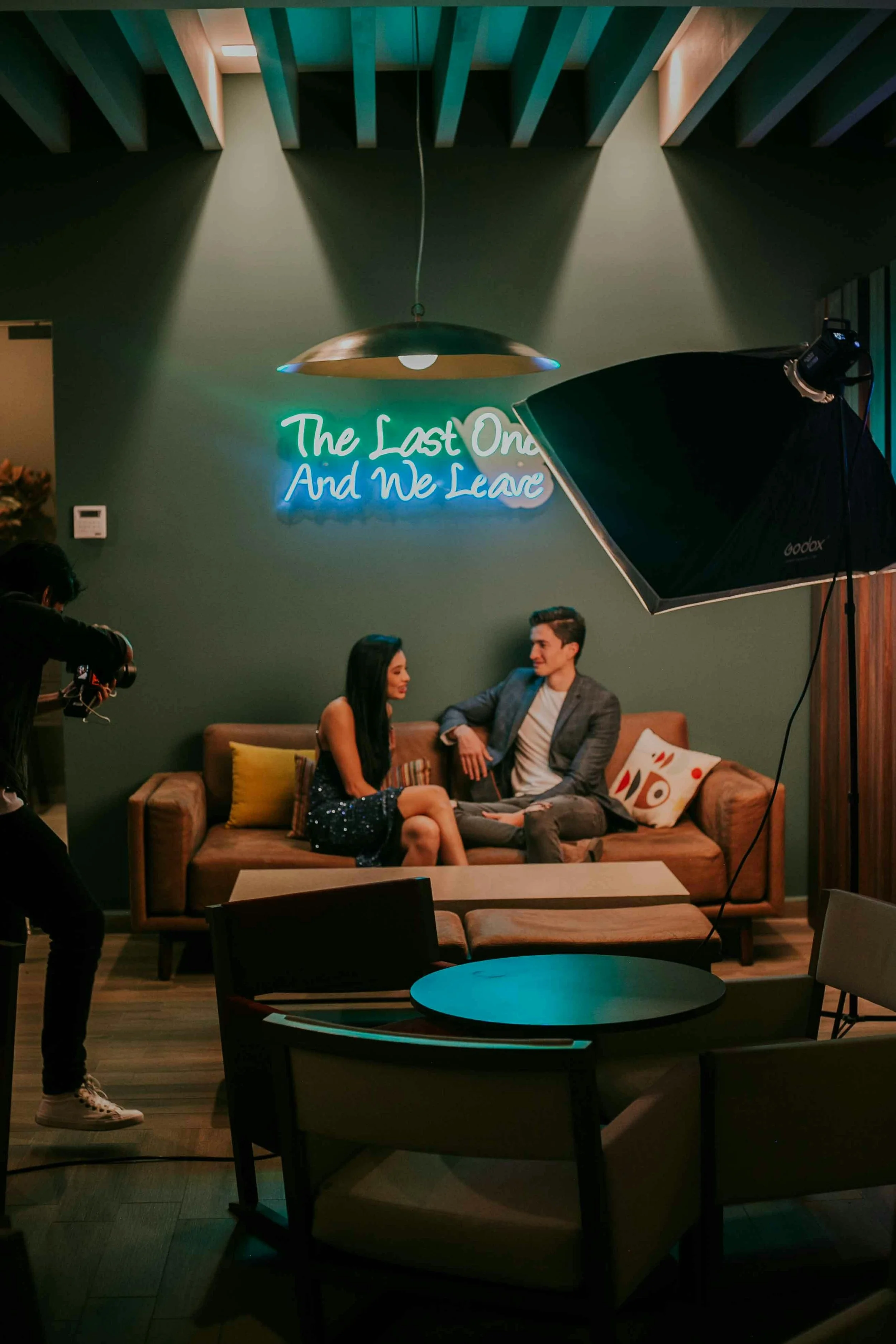 Couple being interviewed on television production set with camera operator and studio lighting