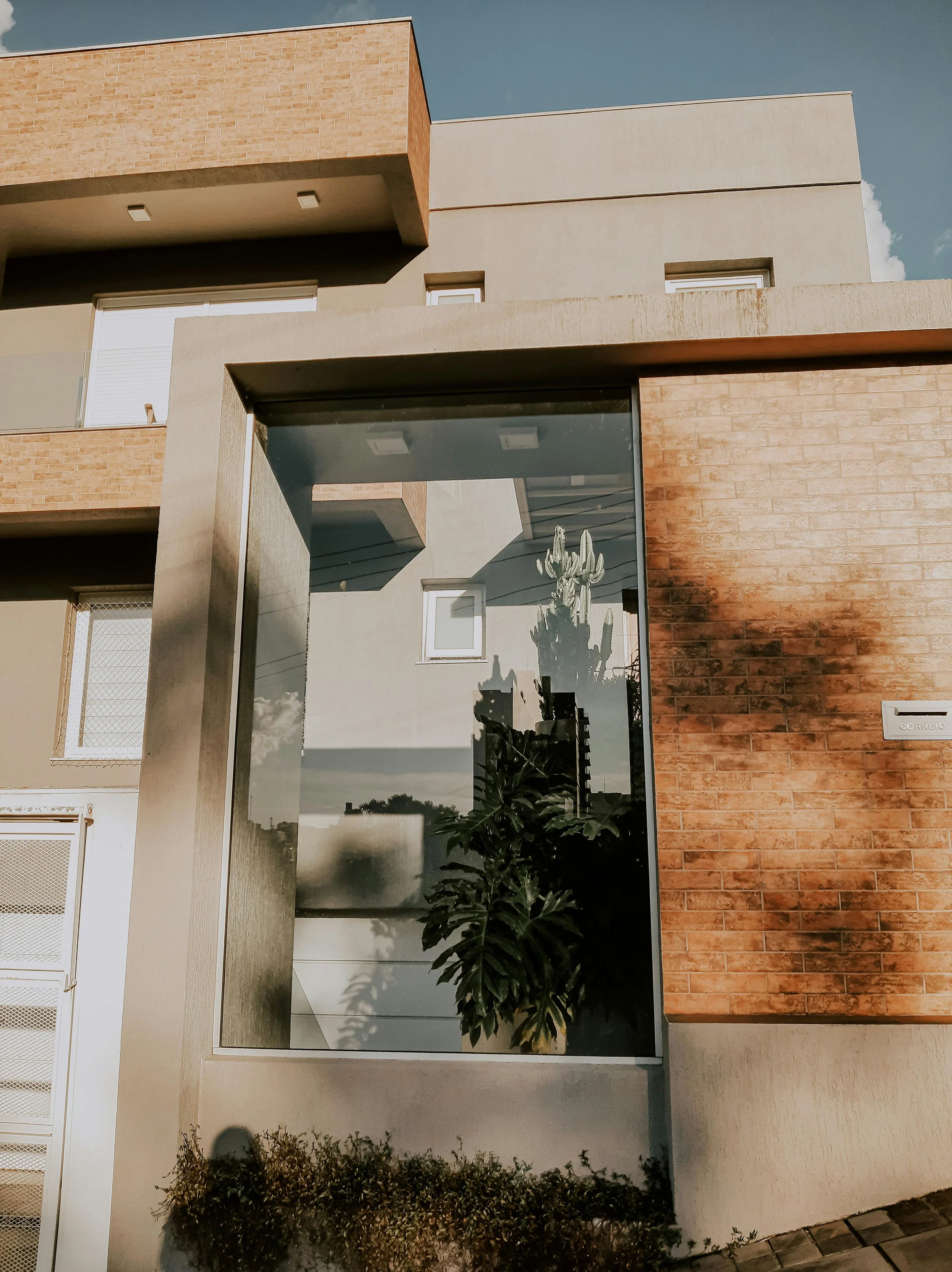 Modern residential property exterior with brick facade and glass panels
