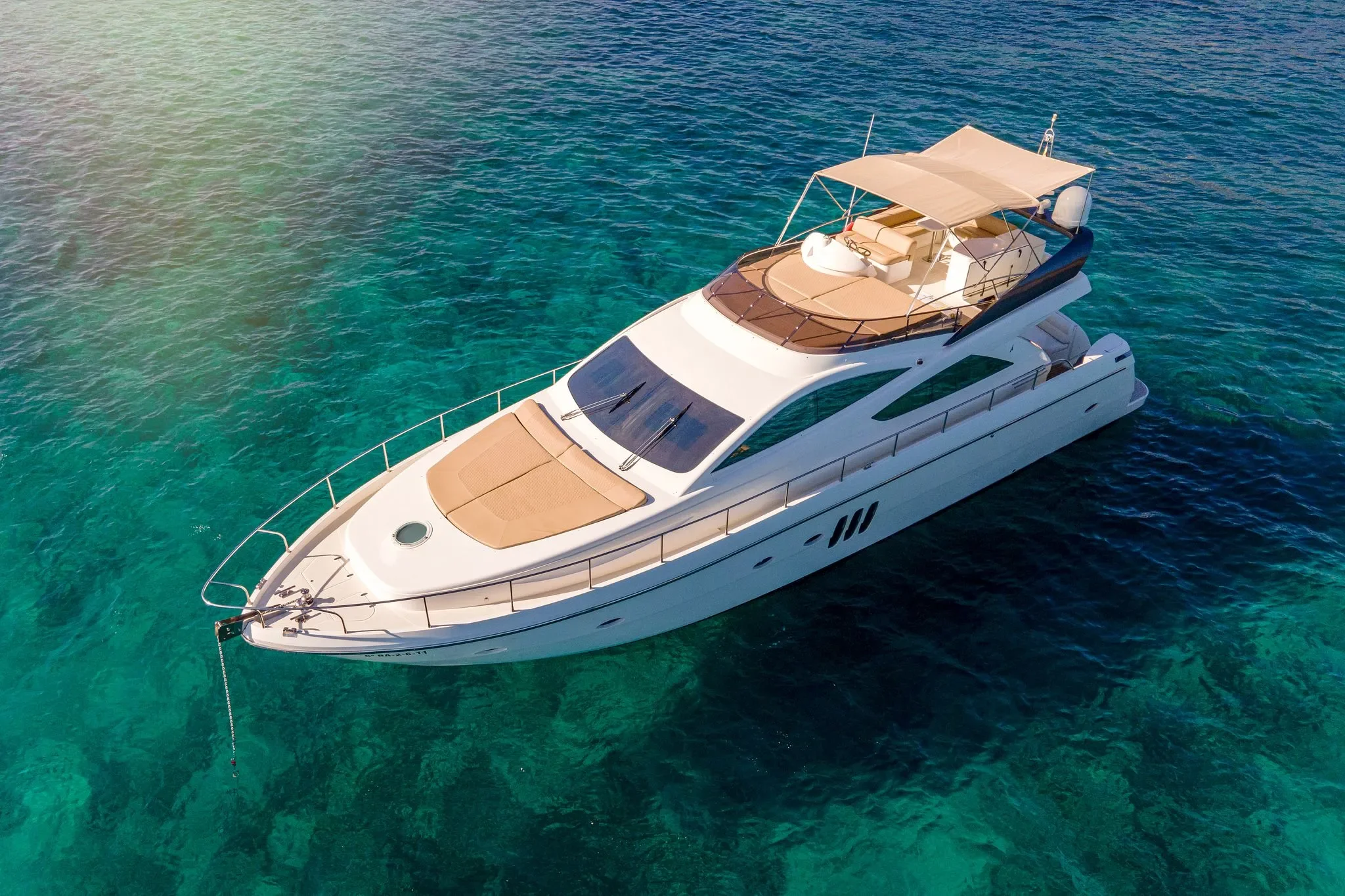Abacus 61 Estela showing spacious bow sunbed and flybridge layout while at anchor