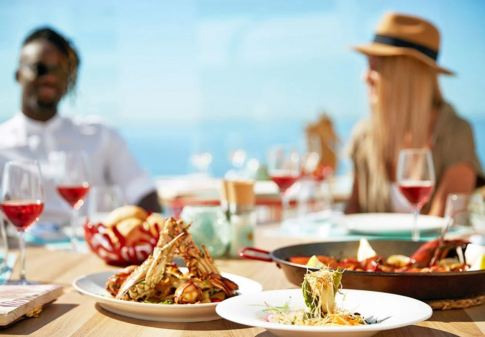 outdoor dining table with seafood dishes and wine