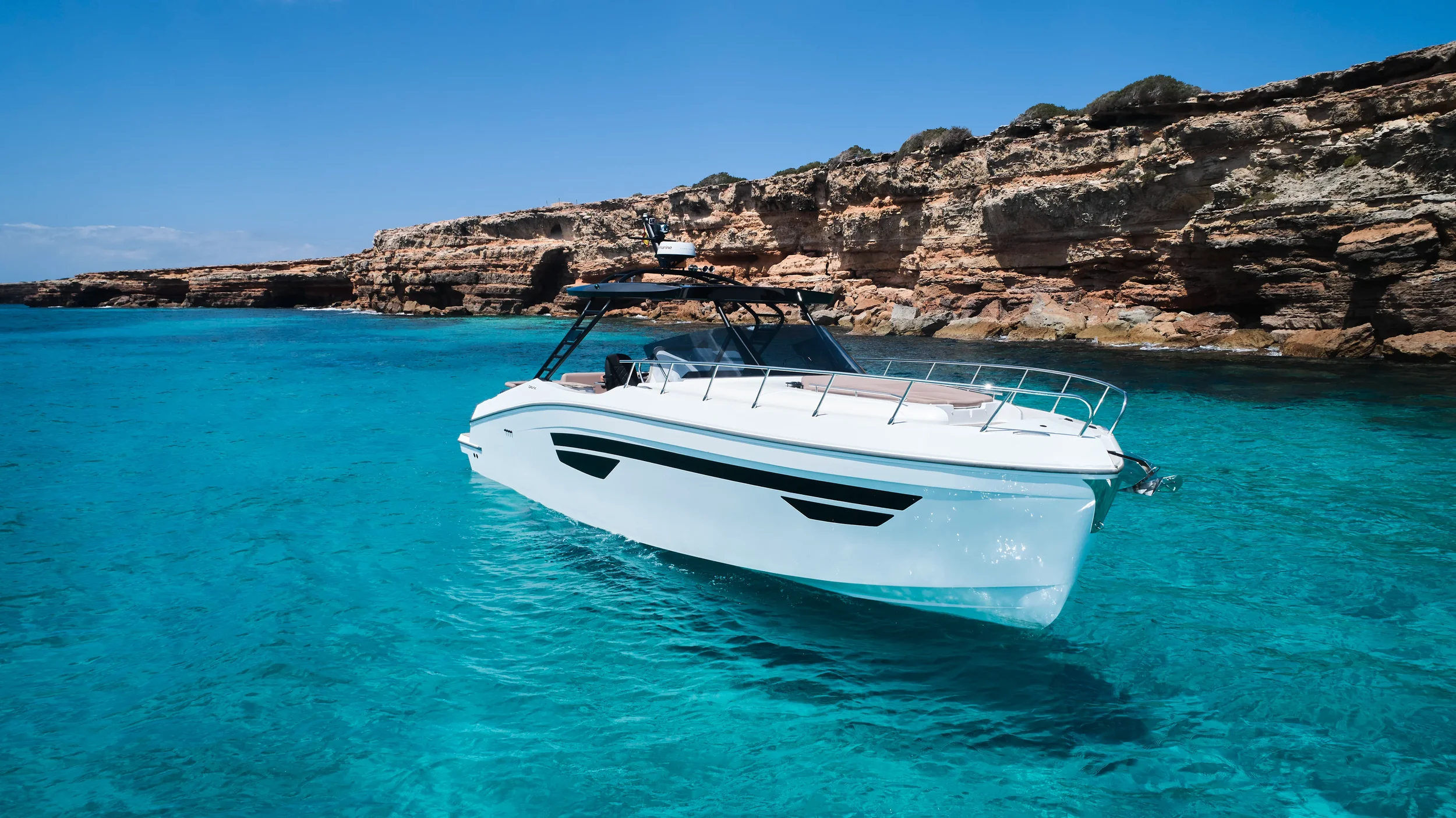 Oryx 38 Santa Cruz anchored in shallow blue water near Ibiza shoreline