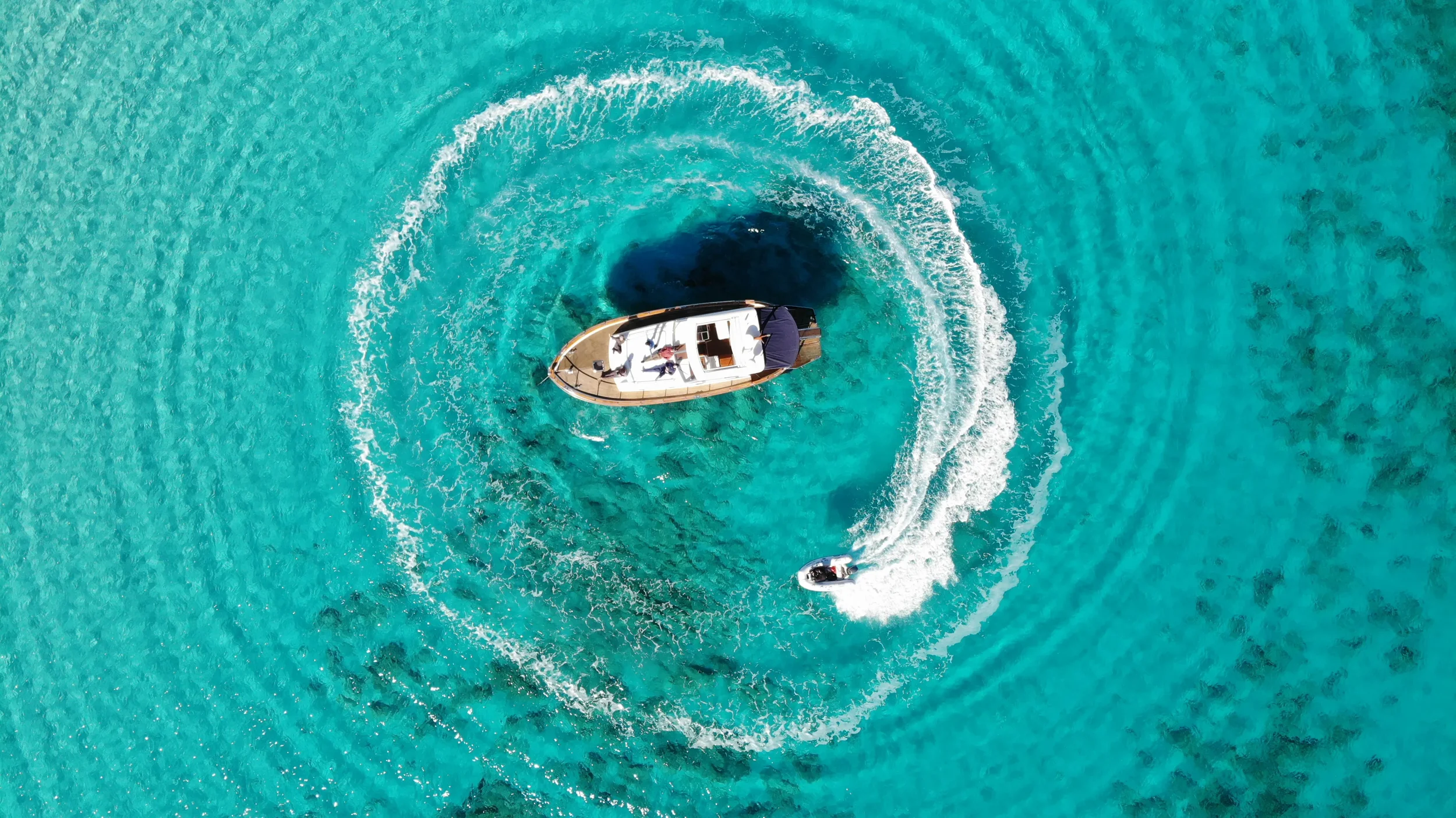 apreamare 45 scamp seen from above making a smooth circular wake over bright turquoise water.