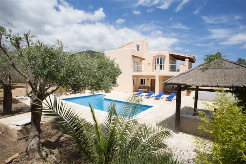 Mediterranean villa with pool, patio, and garden.