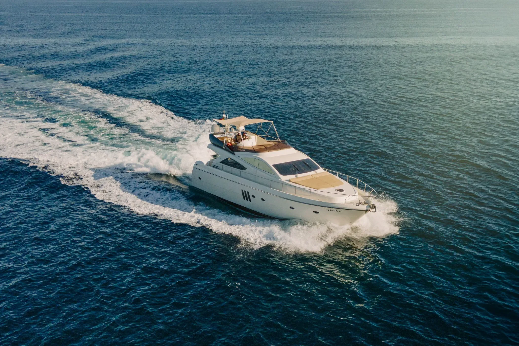 Abacus 61 Estela cruising at speed over clear Ibiza water on a sunny day