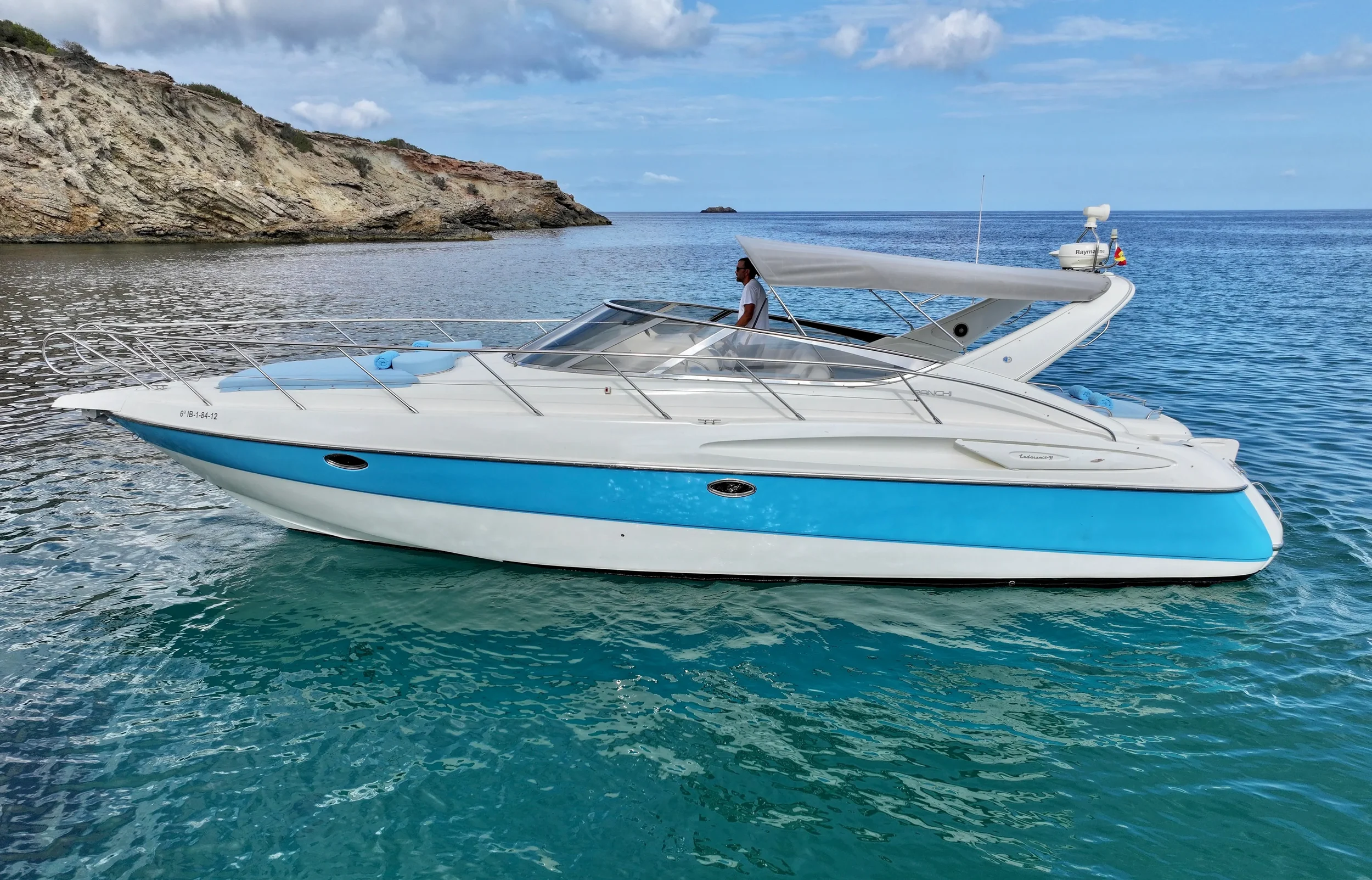 Cranchi Endurance 39 Aroha Ibiza navigating calmly near rocky Ibiza coastline