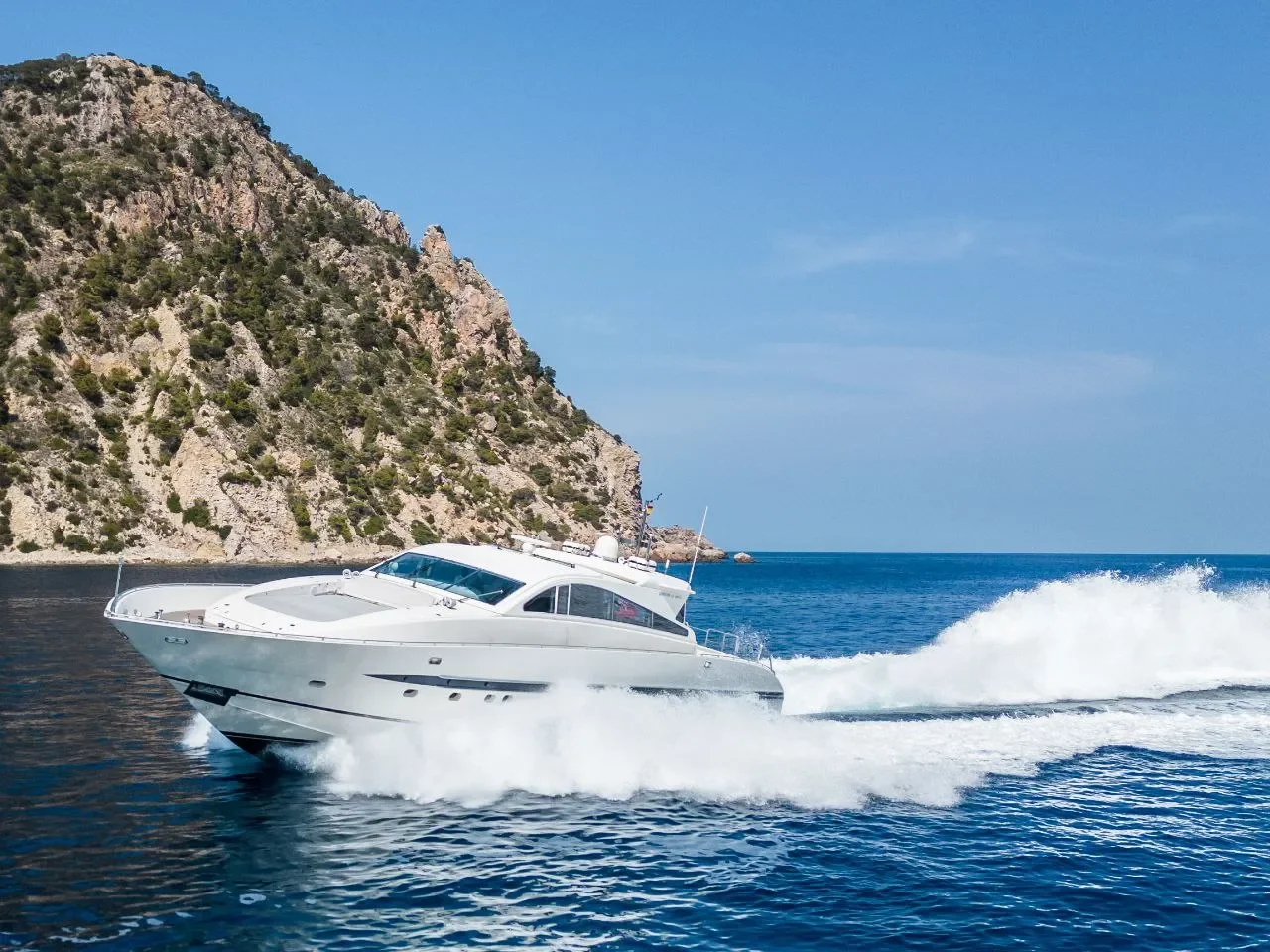 Leopard 27 Byron cruising past the coastline with mountains in the background
