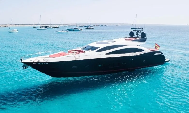 Luxury yacht anchored in clear blue ocean with other boats in the background