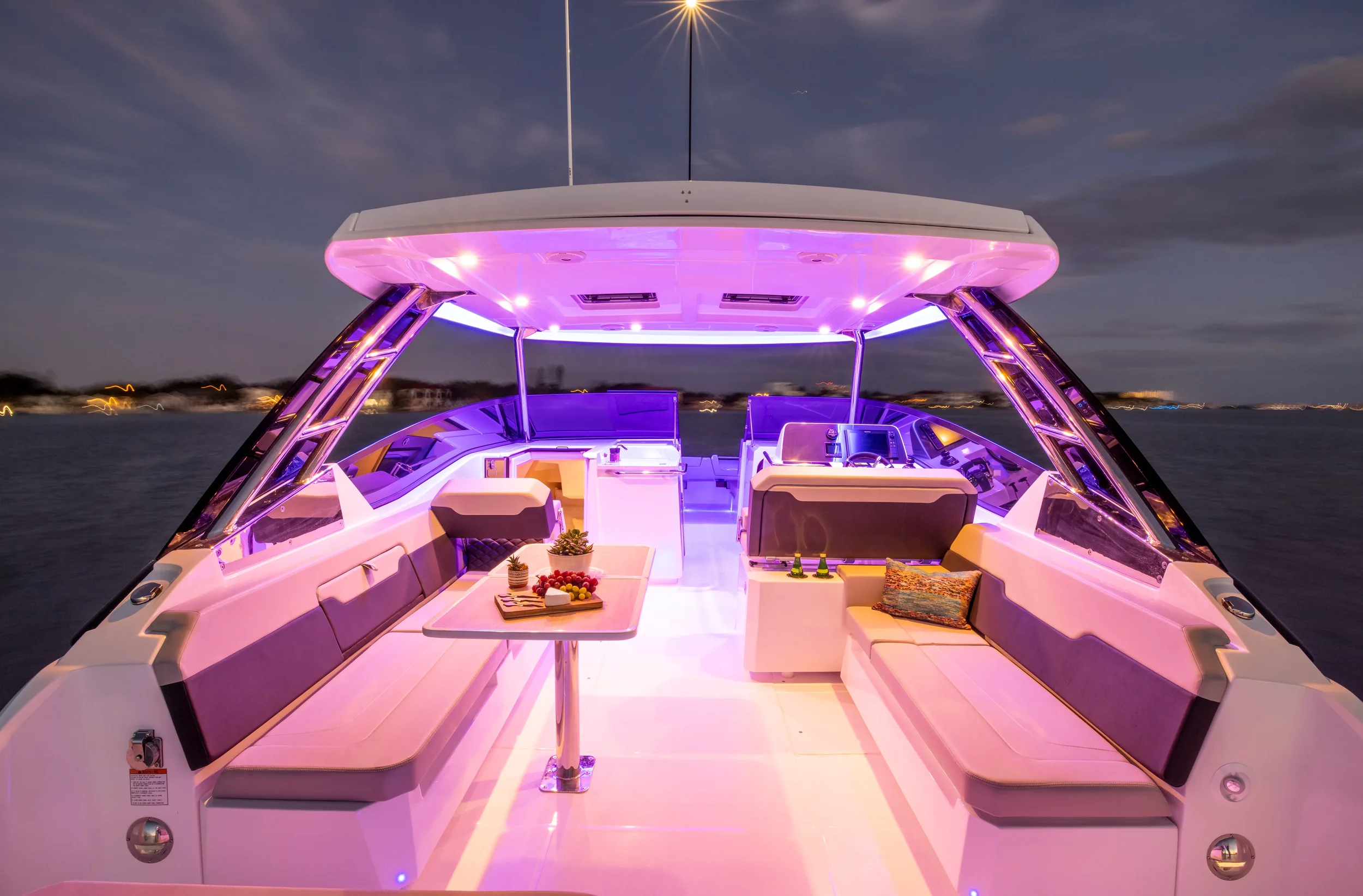 aquila 32 sport illuminated cockpit at dusk showing ambient lighting and evening charter atmosphere