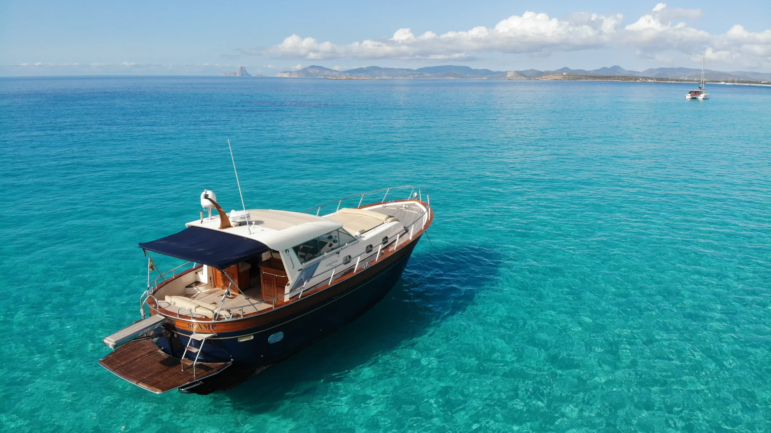 apreamare 45 scamp cruising over glassy clear water with Formentera visible in the distance.