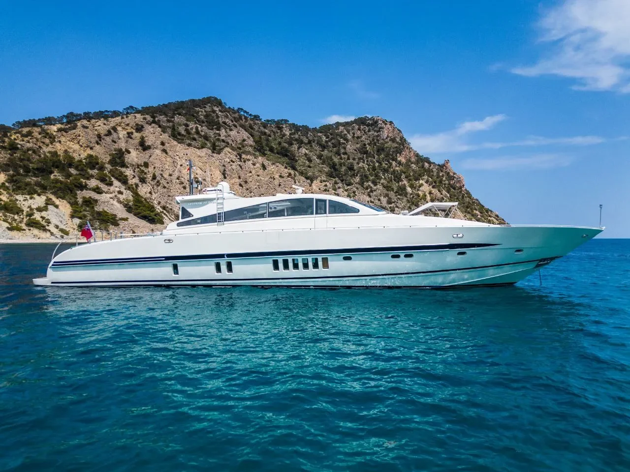 Leopard 27 Byron side profile drifting near the coast in clear turquoise water
