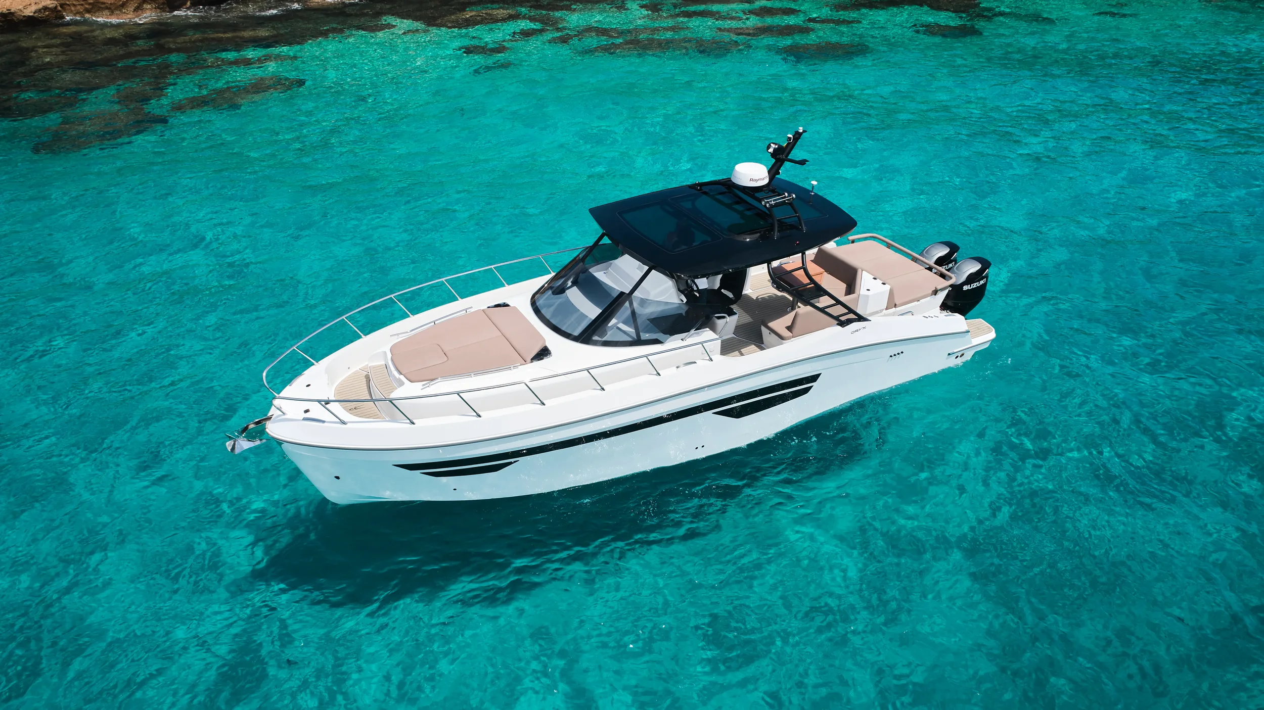 Oryx 38 Santa Cruz anchored near rocky Ibiza coastline with clear water