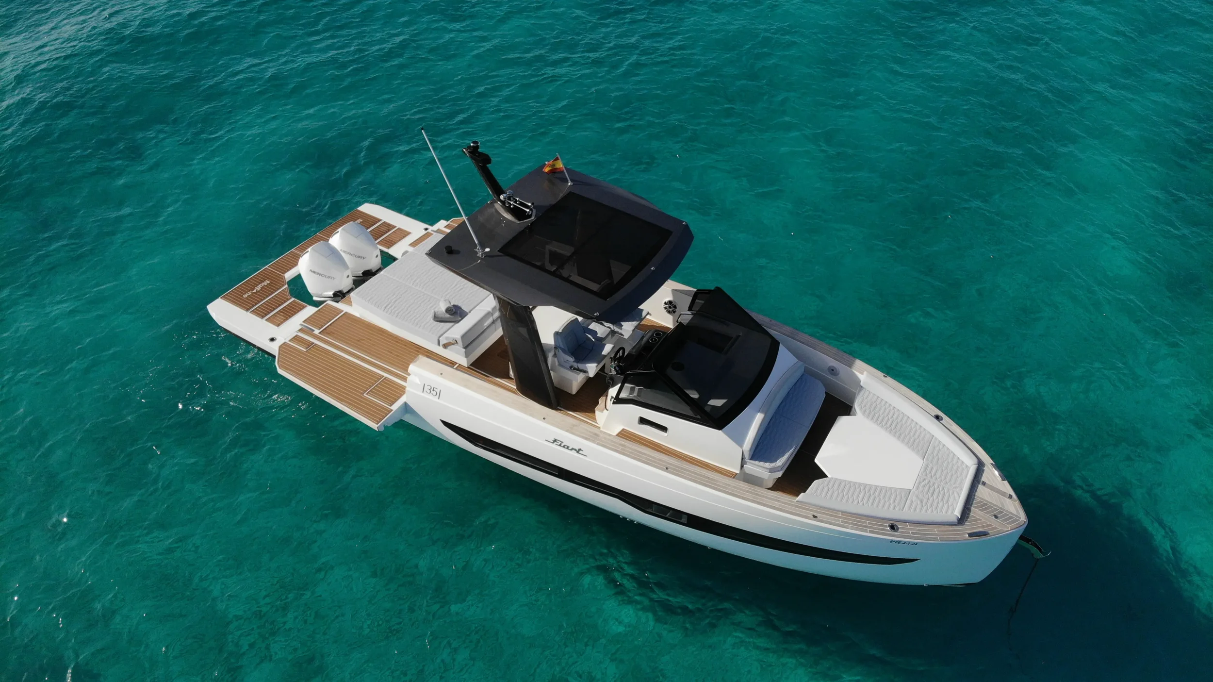 Aerial shot of the Fiart 35 Martone W cruising in bright blue water showing the open layout and spacious bow sunbed.