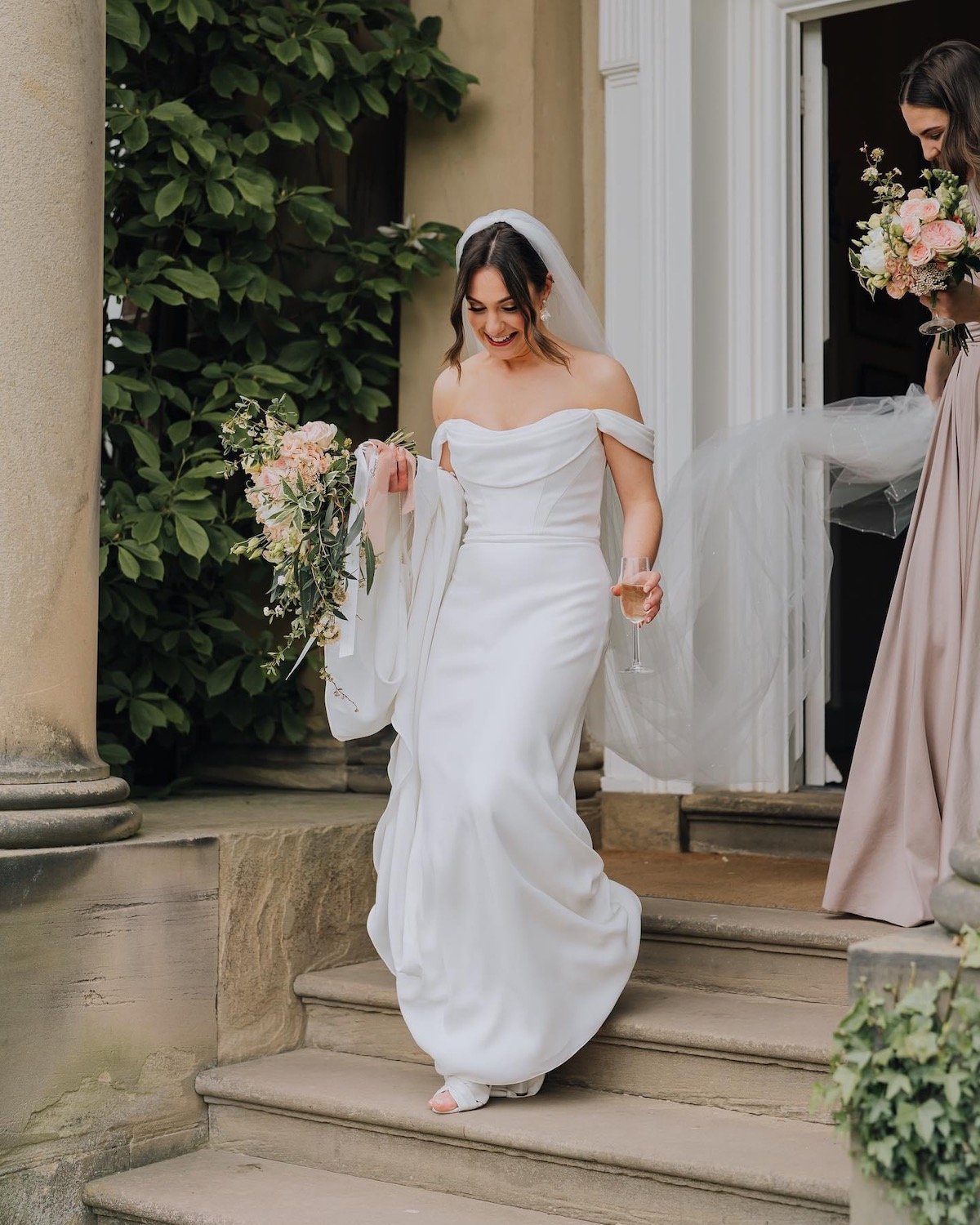 Brunette Bride holding bouquet with a Soft Romantic Makeup Look at Iscoyd Park walking down the stairs