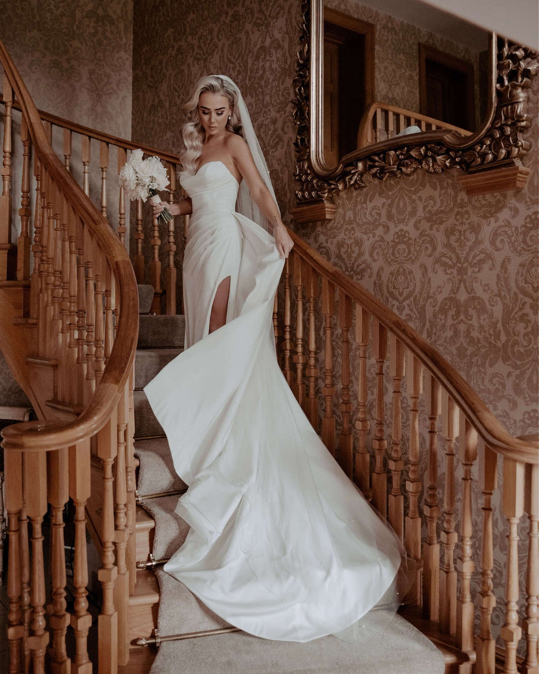 Bride poses on the stairs of Merrydale Manor.