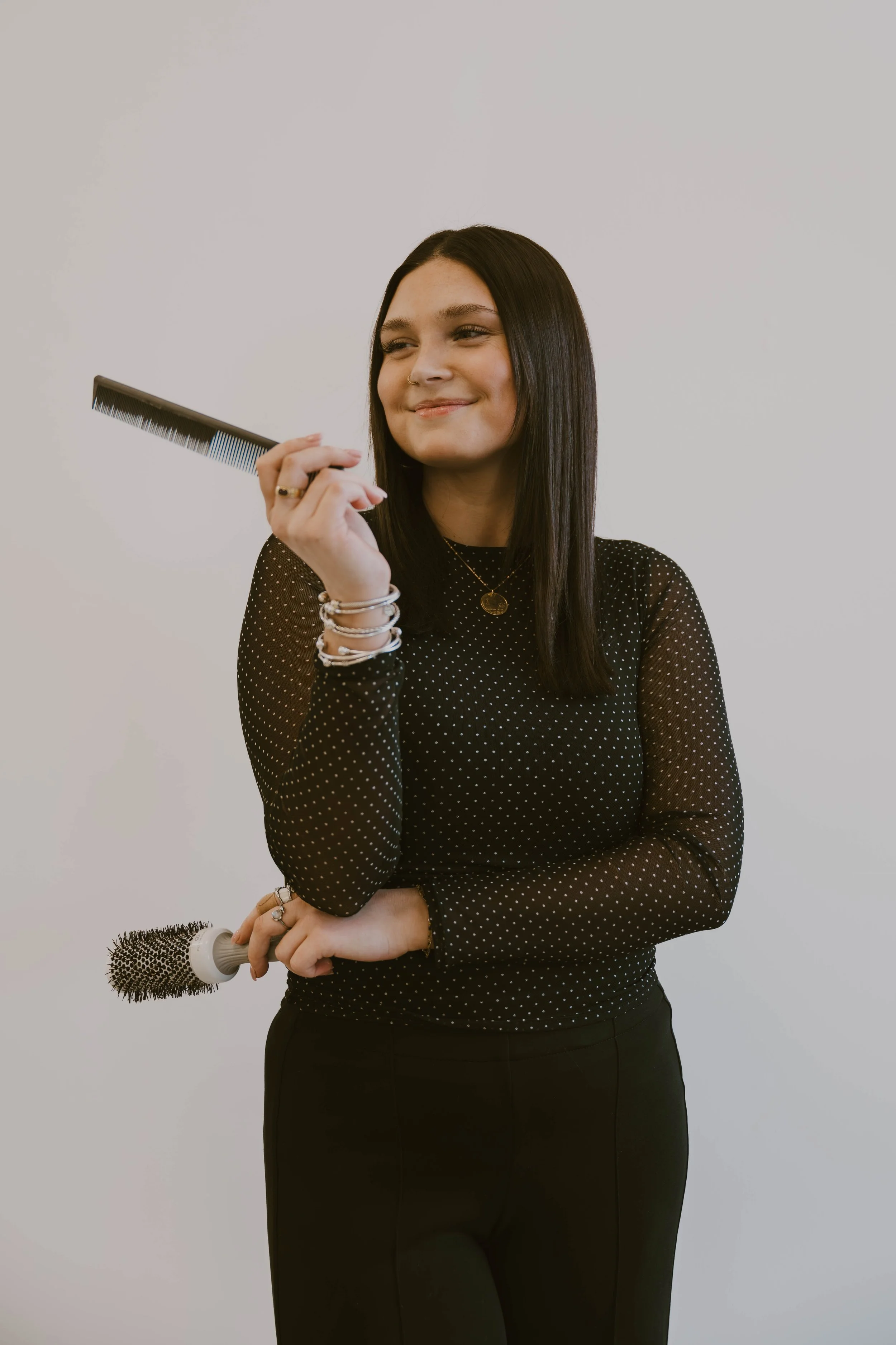 Color specialist in walpole nh holding a haircutting comb and blowdry brush