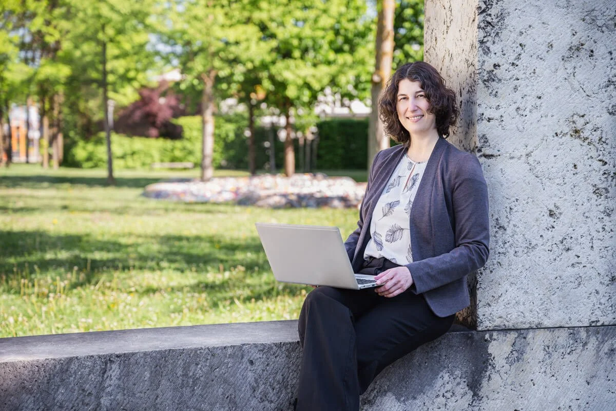 Webdesignerin Veronika Schachinger bei der Arbeit am Laptop im Park