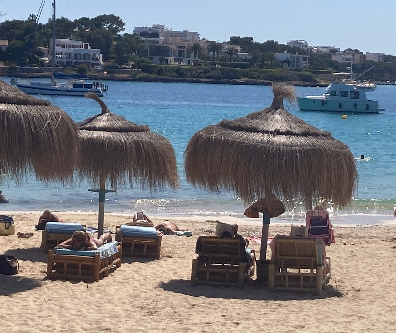Sonnenschirme und Sonnenliegen am Strand S'Arenal in Portocolom