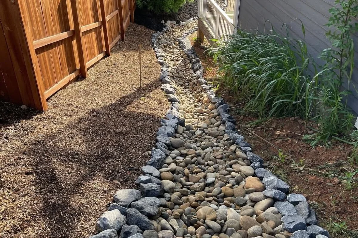 Decorative dry creek bed drainage system installed to direct stormwater in Asheville, North Carolina.