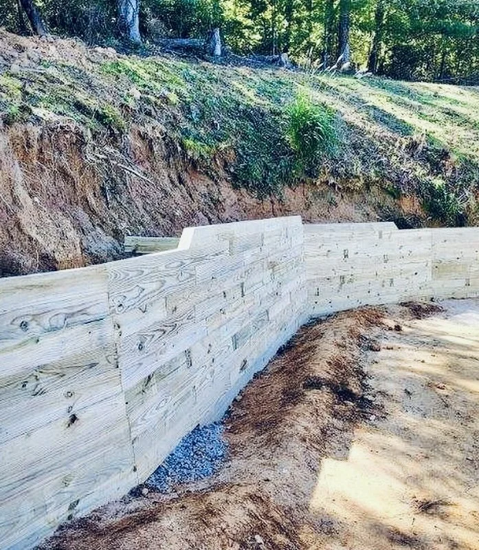 Side view of timber retaining wall showing bank above design by Greenspan Landscaping Company in Black Mountain, NC.