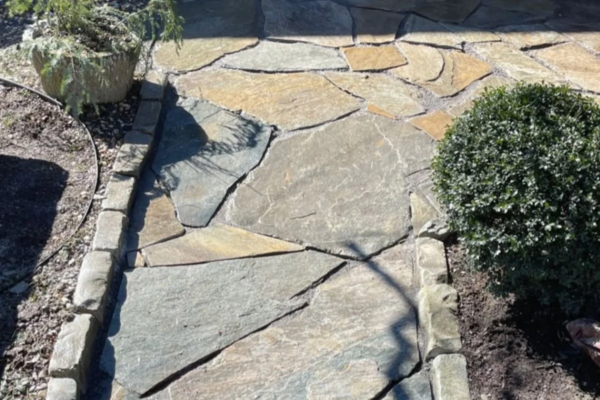 Natural flagstone walkway with stone edging installed for residential landscape in Fairview, NC.