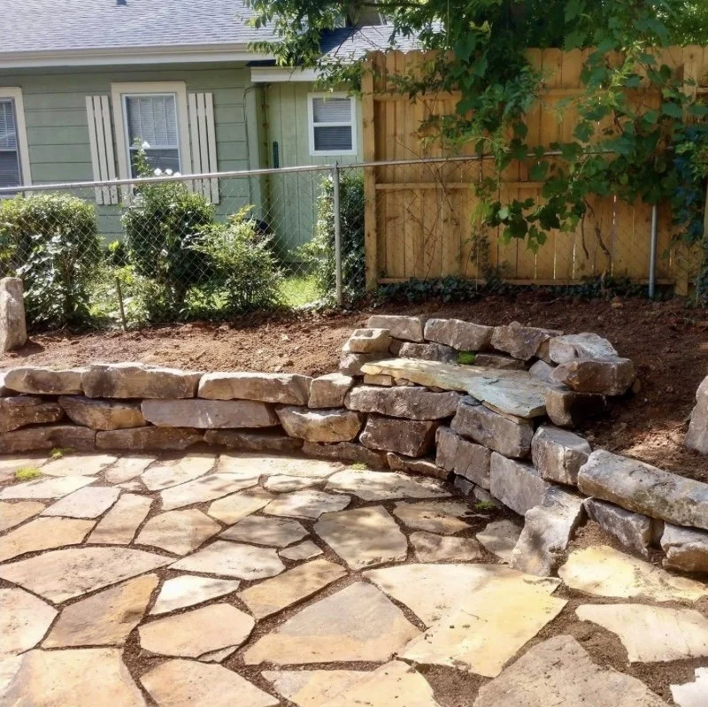 Custom natural stone retaining wall and flagstone patio built by Greenspan Landscaping in West Asheville