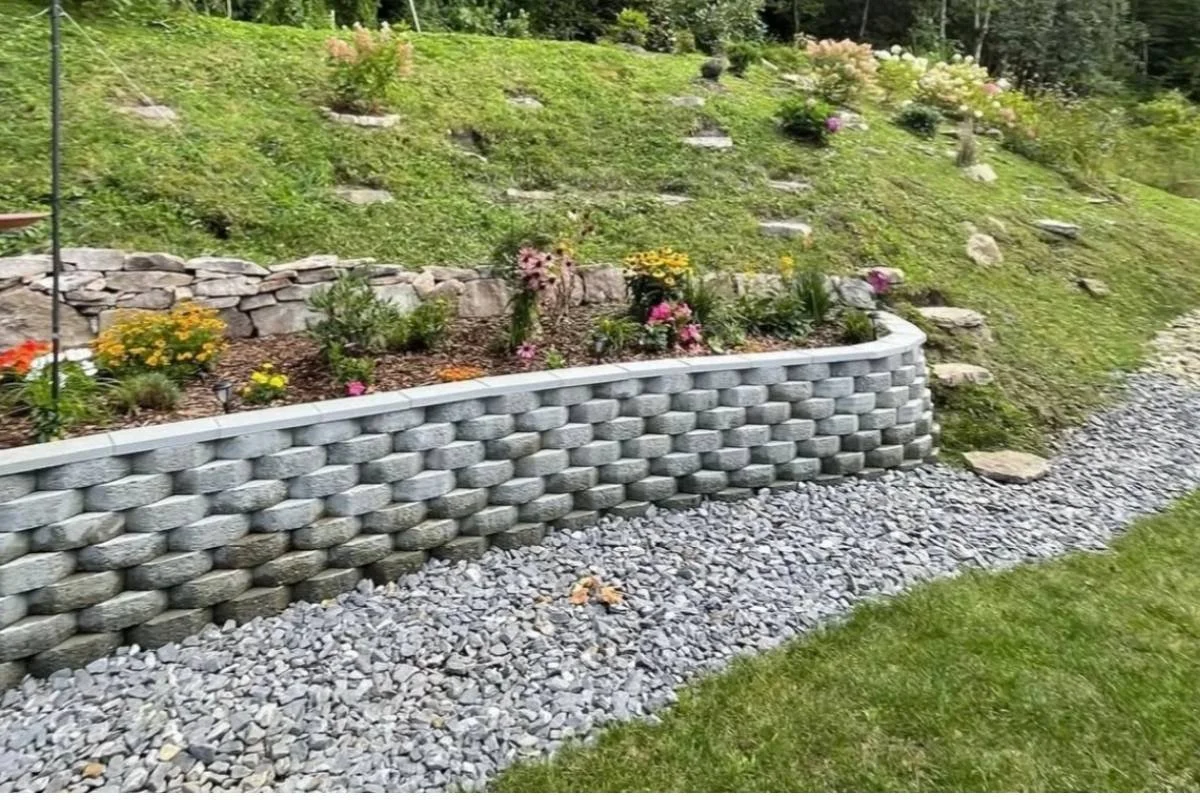 Concrete block retaining wall installation on a sloped yard in Marion, North Carolina.