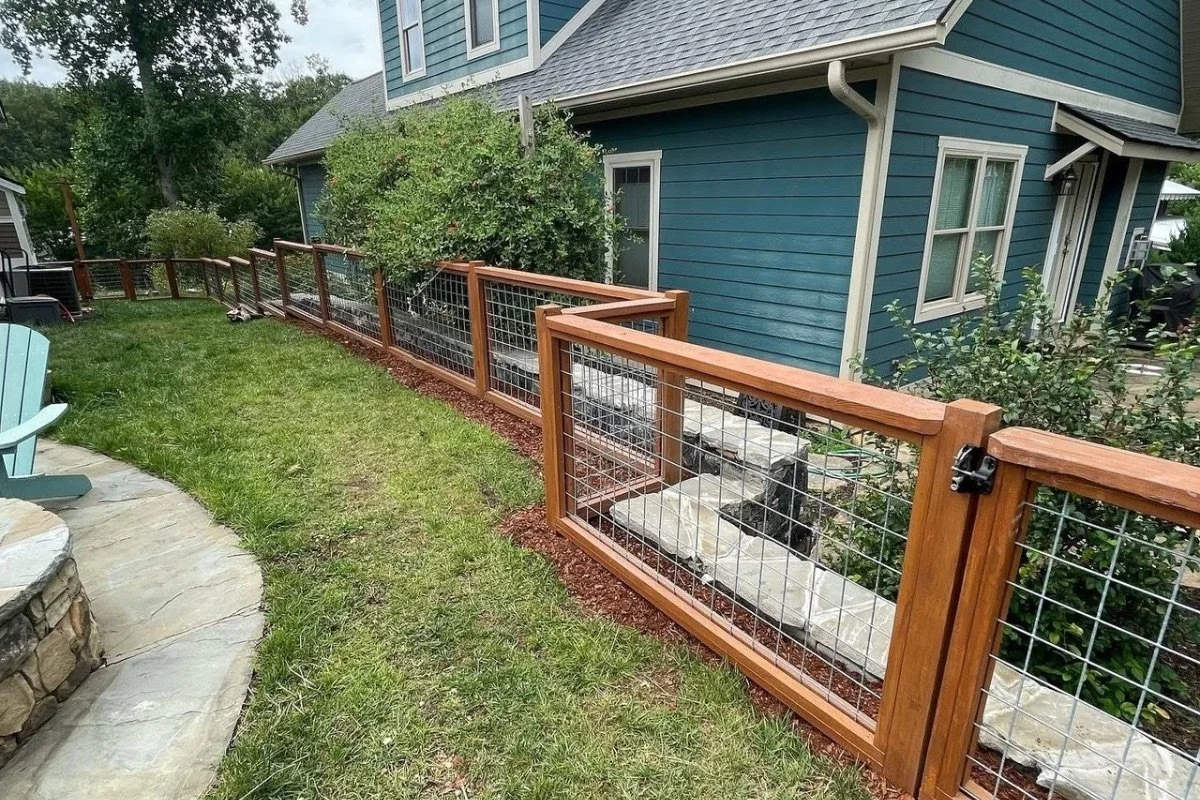 Wood post and wire panel fence installed along a backyard landscape in Marion, North Carolina.