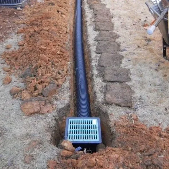 Drainage pipe and catch basin installed behind retaining wall to control water runoff in Western North Carolina