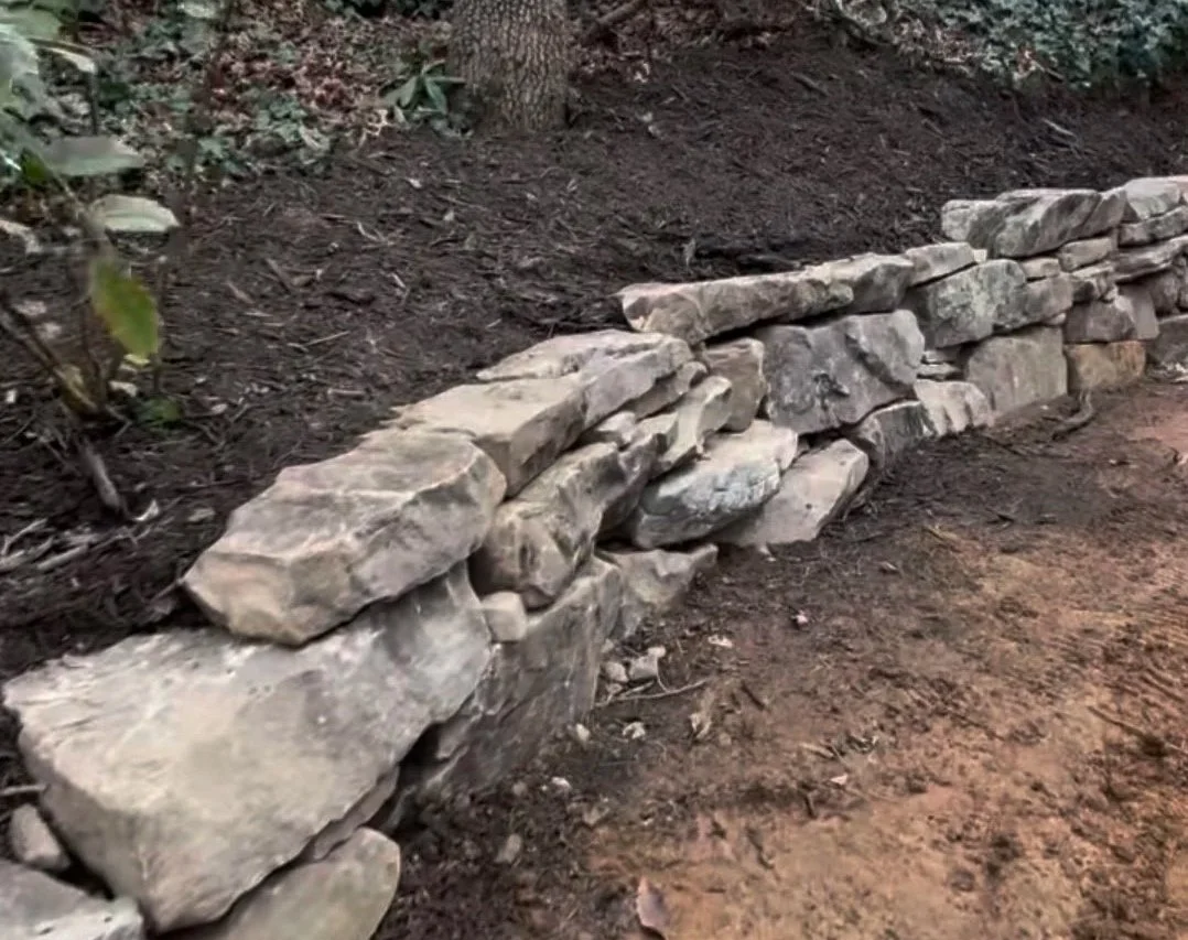 Natural boulder retaining wall with large stone steps built on a sloped yard in Black Mountain, NC