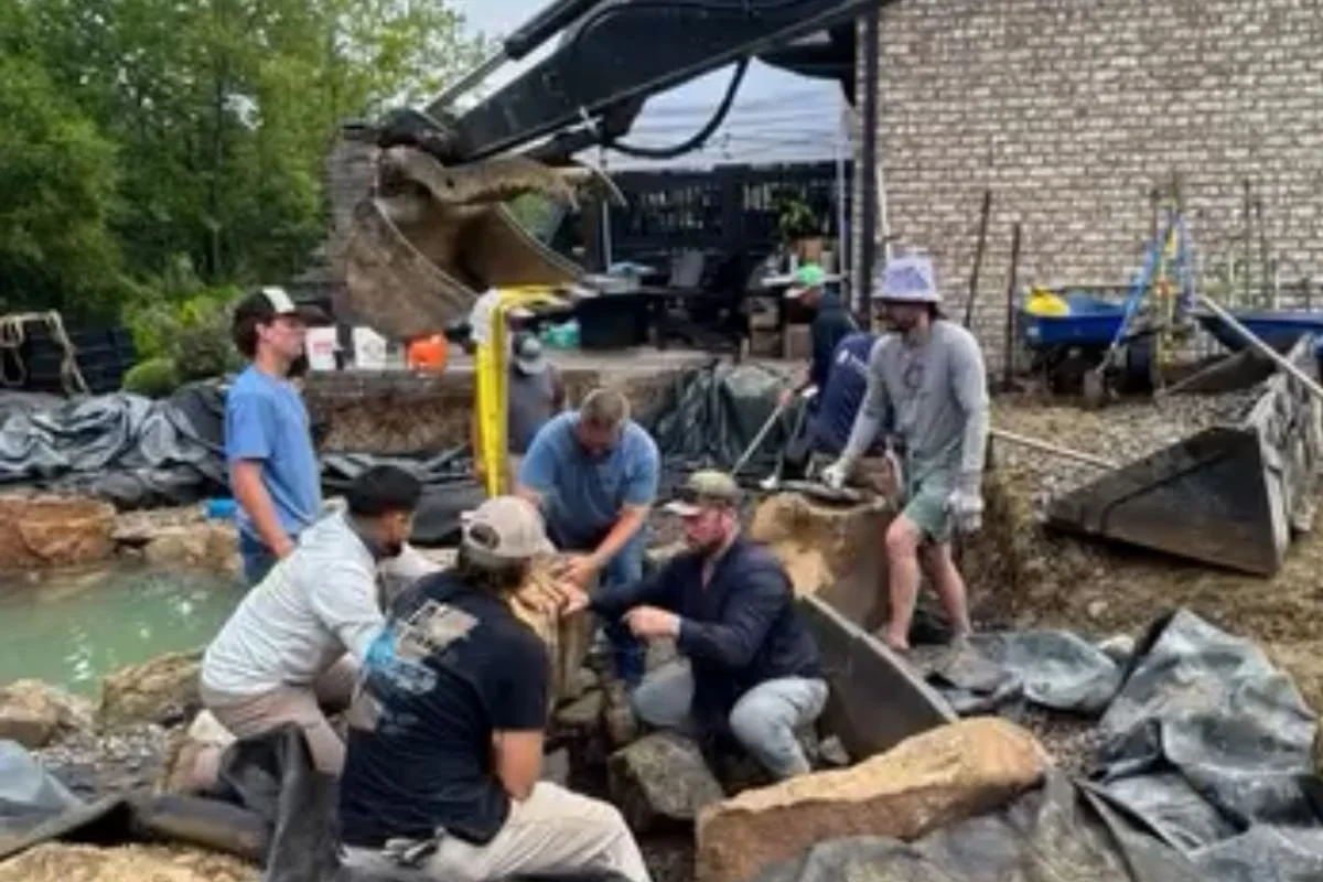 Landscaping crew installing natural boulder retaining wall in Asheville NC