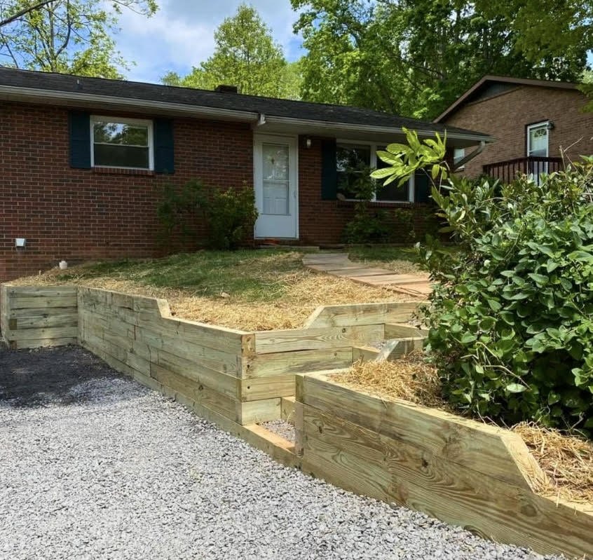Timber retaining wall installation completed by Greenspan Landscaping Company in Black Mountain, NC for a brick home residential service.