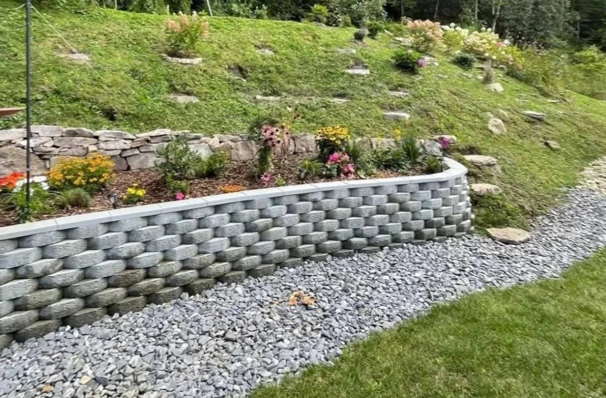 Curved concrete block retaining wall for slope stabilization and drainage by Greenspan Landscaping in Marion, NC