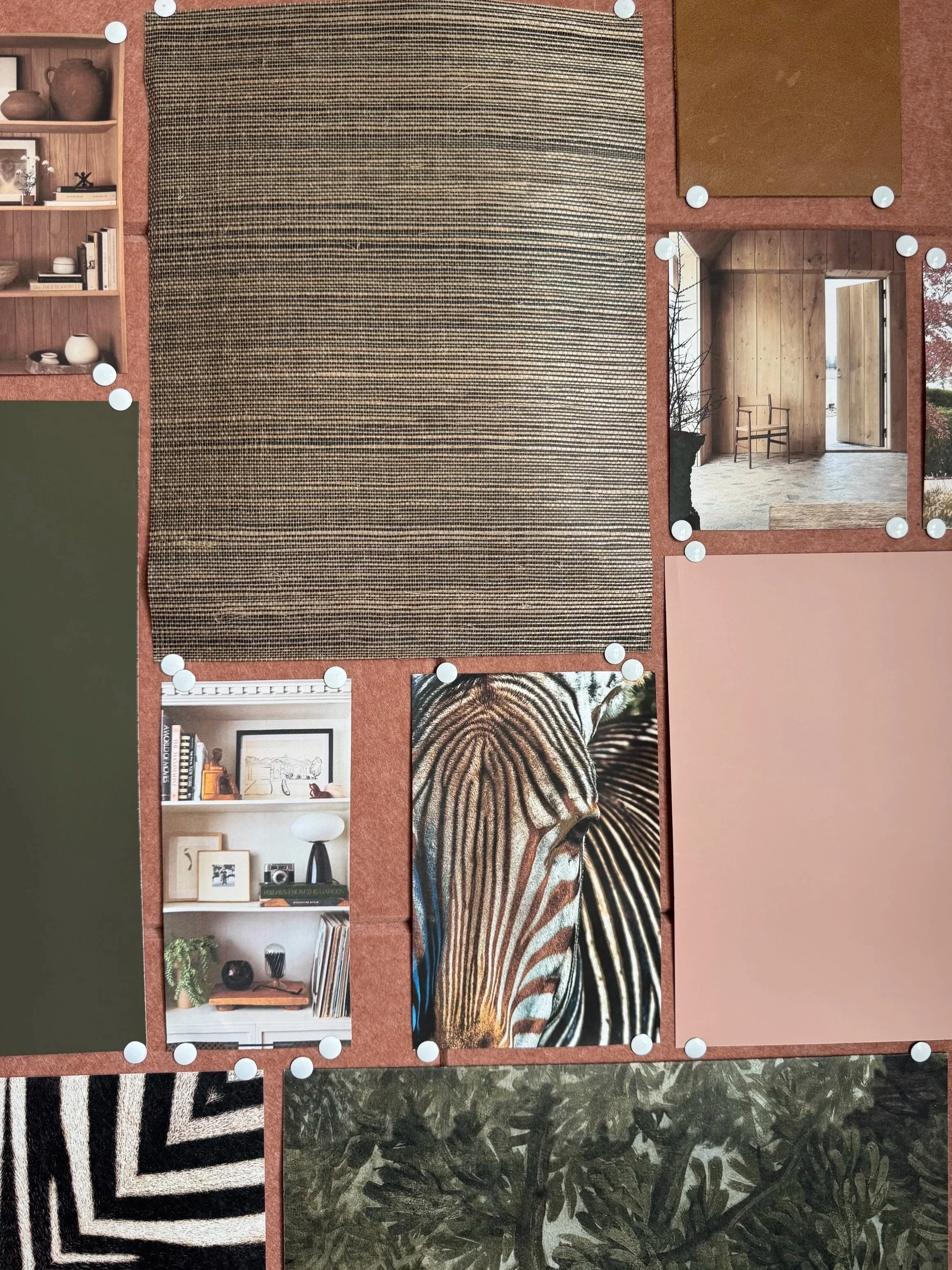 A bulletin board displaying various pictures and textures, including a striped rug, a photo of a zebra, a room with wooden walls and a chair, a bookshelf with decor, and abstract art pieces, all held in place with white push pins.