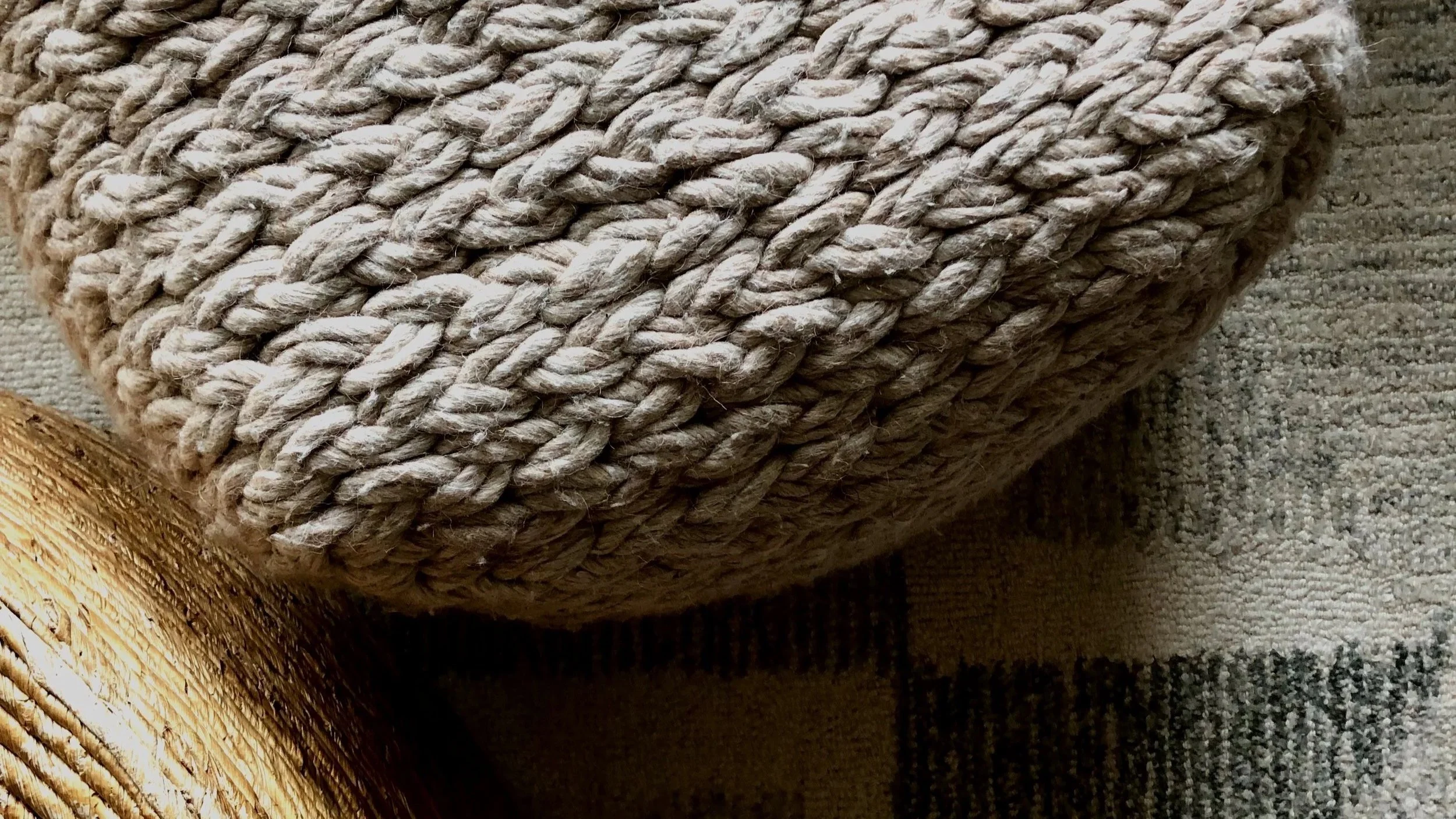 interior design living room, wool living room rug, wool pouf, woven coffee table