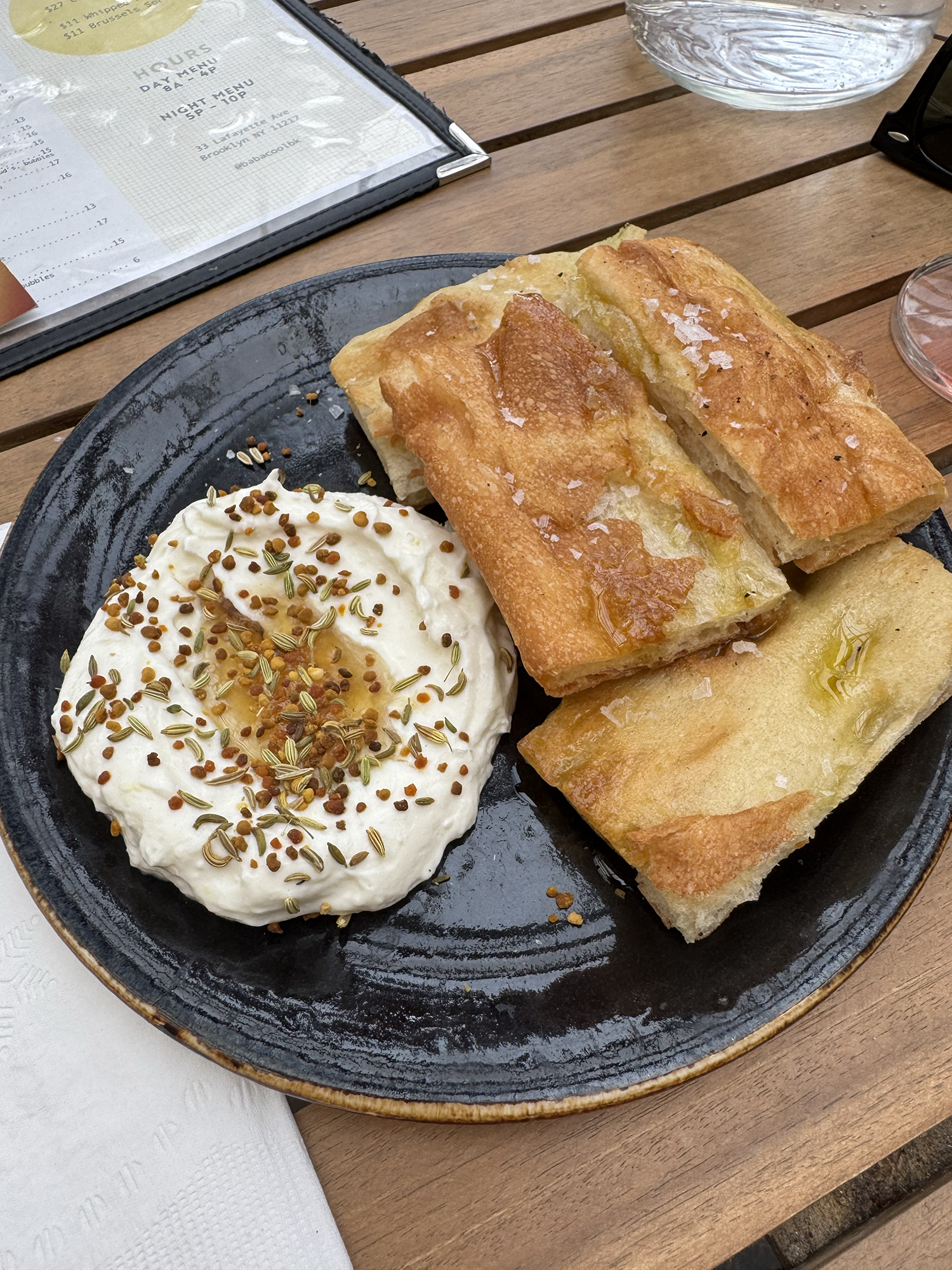  A plate with bread and whipped ricotta with a little pool of oil and spices on top. 