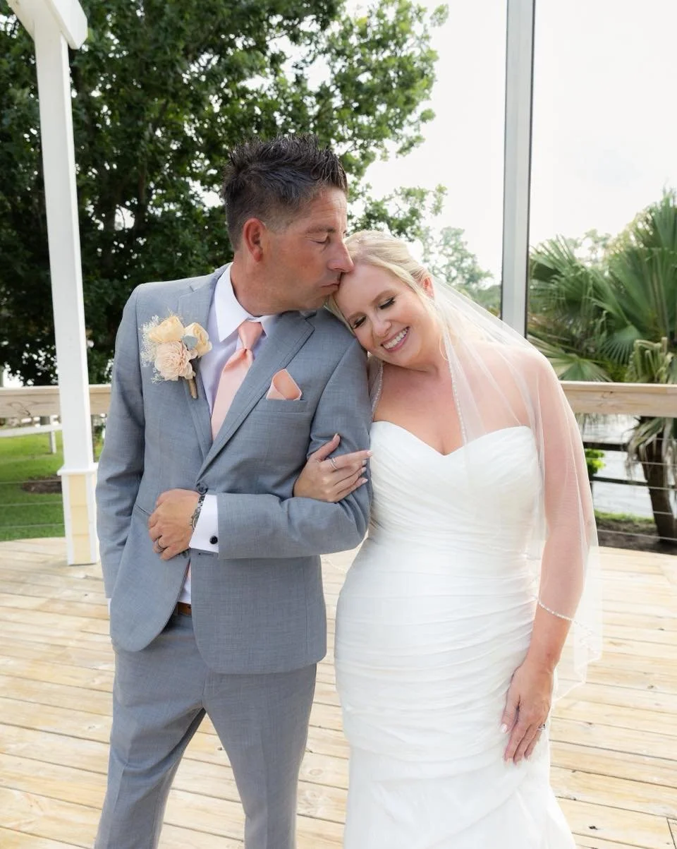 On May 31, 2025, Jenny walked down the aisle to Chris in a gown as radiant as her love. Surrounded by joy (and two sweet pups), their forever began. 💍

Venue: Dido&rsquo;s River Rendezvous
DJ: Darker Side DJs &amp; Photobooths
Photographer: Divine P