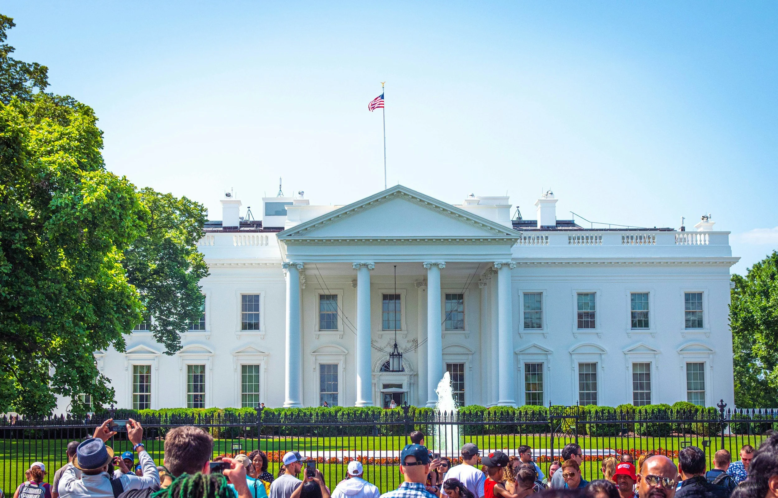Tourists gathered at the White House fence line, illustrating the presidential security perimeter targeted in the May 23 checkpoint attack analyzed in this strategic intelligence report