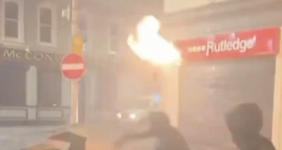 Street-level footage of a building fire during the June 2026 Belfast anti-immigration riots, sourced from @WarMonitor3 on X