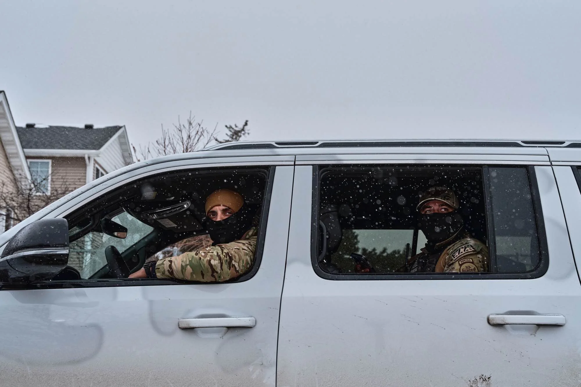 Masked ICE agents inside a vehicle, representing the federal agents targeted for identification and tracking under CrimethInc's published surveillance protocol