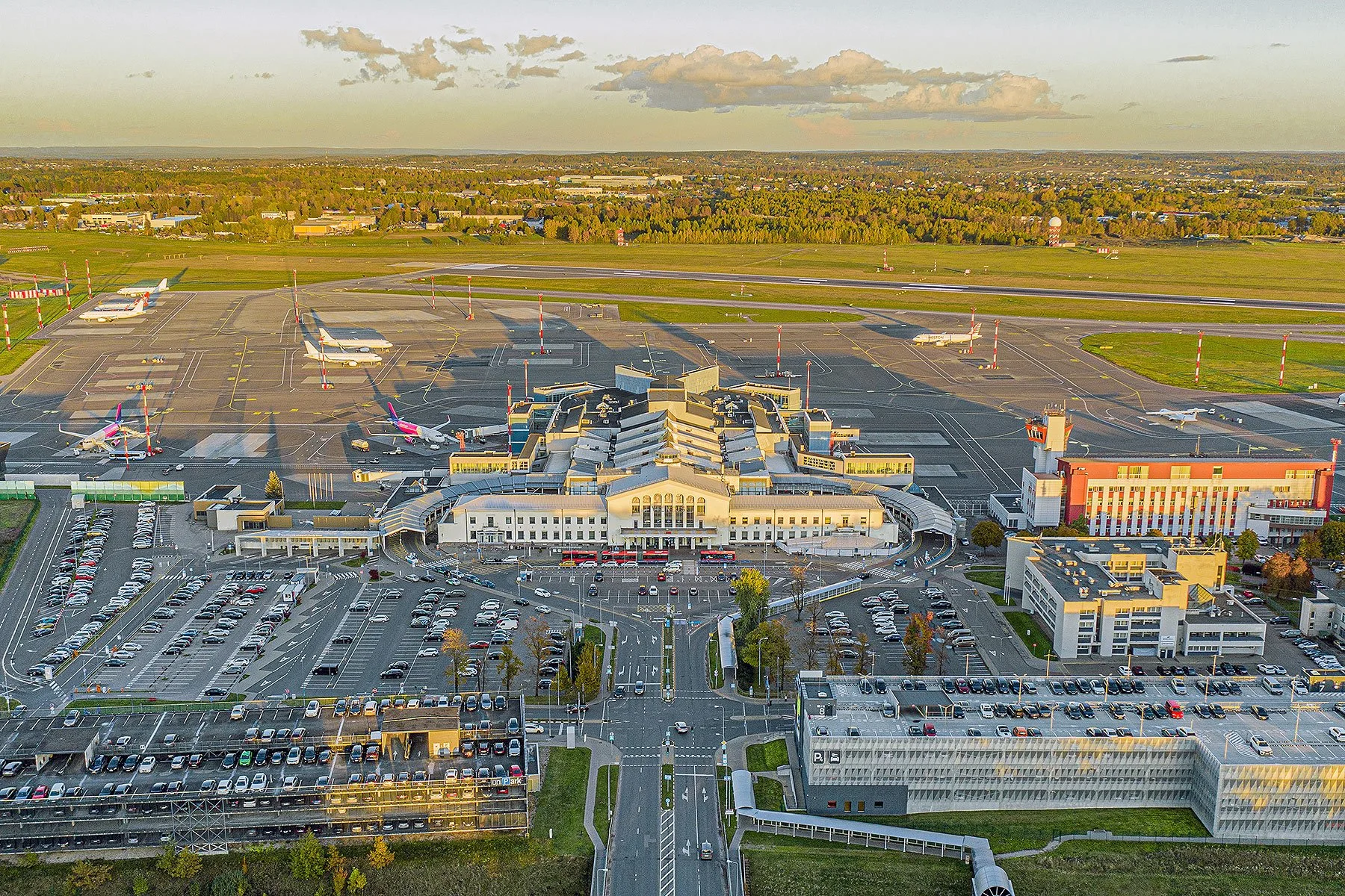Aerial view of a Lithuanian airport showing runways, terminal buildings, and parked aircraft