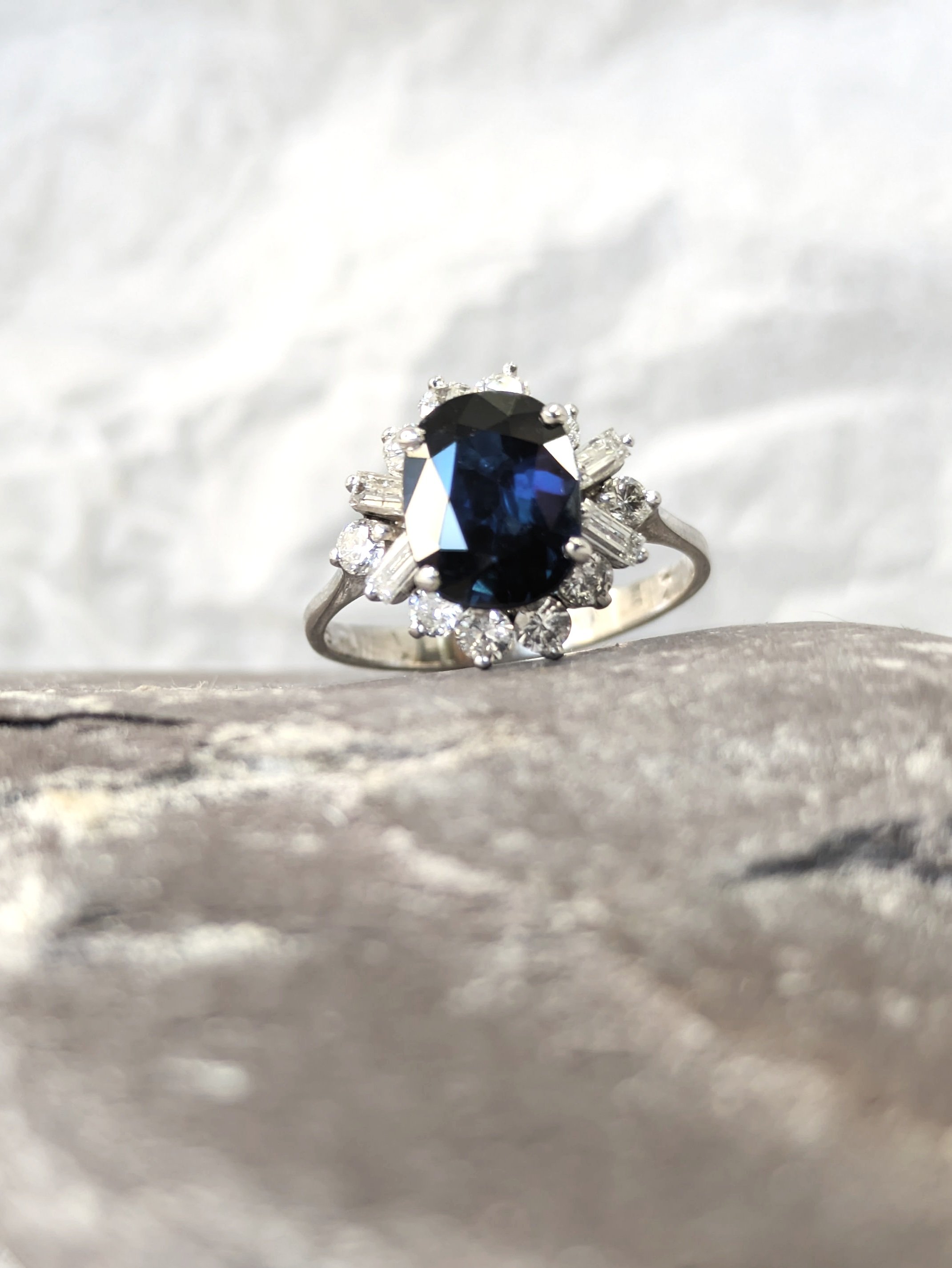 Oval Sapphire & Diamond Baguette Engagement Ring display in a solid Sea Stone