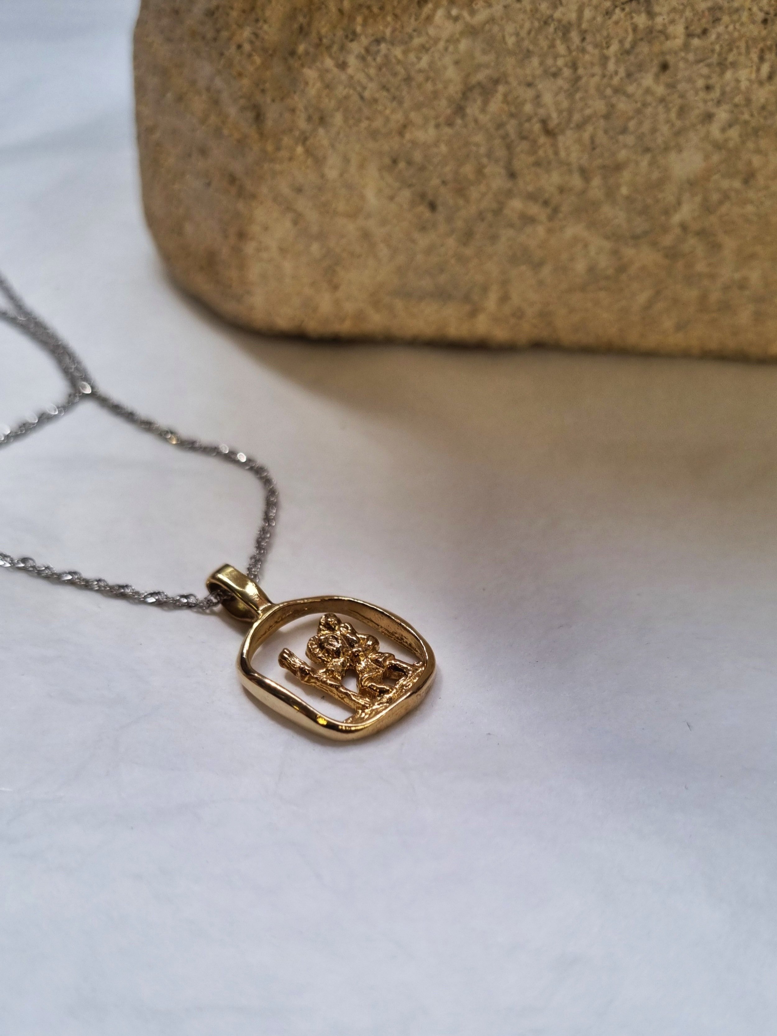 Gold pendant and chain on light background