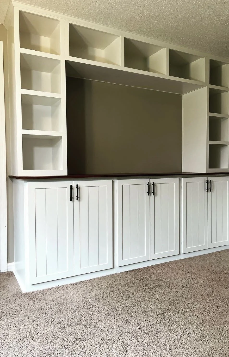 Built-ins custom cabinets painted white with doors and cubbies and black handlesin Elma NY.