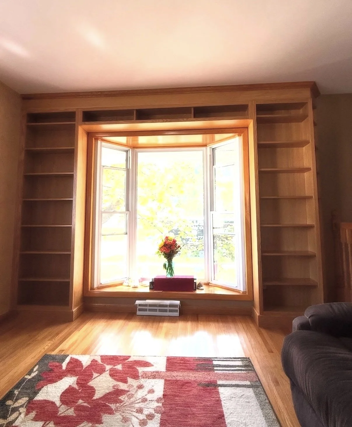 Built-In Bookshelves wooden made from Red Oak around a window with crown molding in Eden, NY.