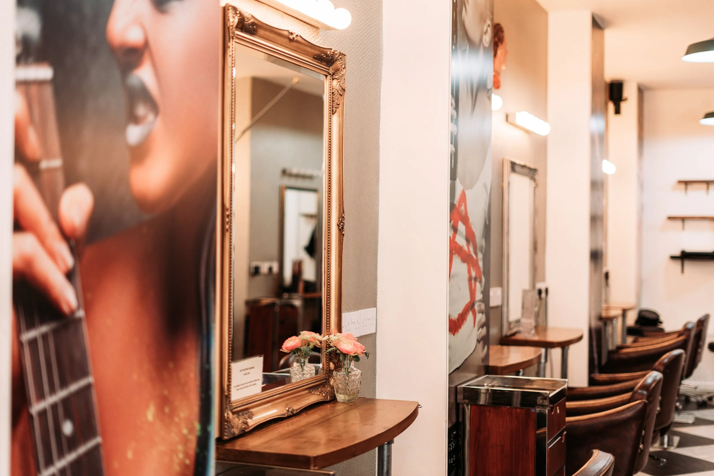 Interior view of a hair salon with chairs, mirrors, and artwork on the walls.