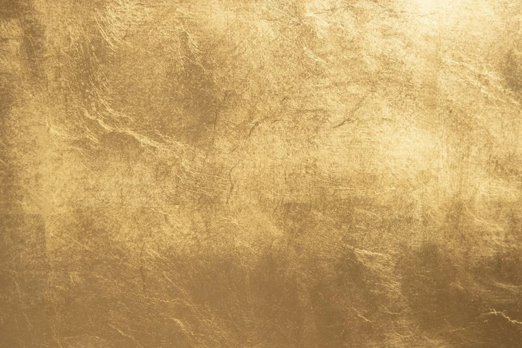 A textured gold surface with a rough, uneven appearance.