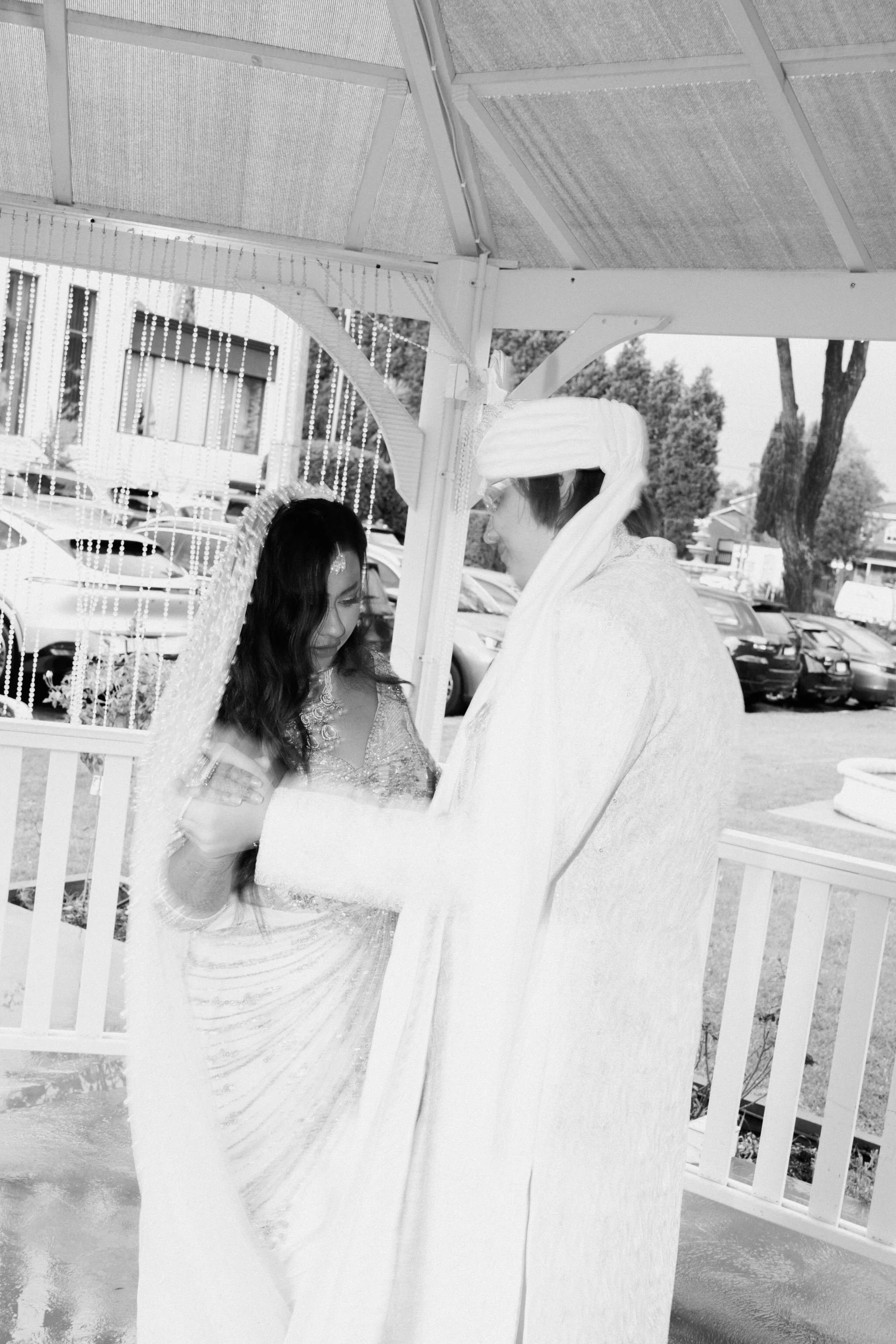 Bride and Groom wearing traditional Bengali outfits, dancing in black and white