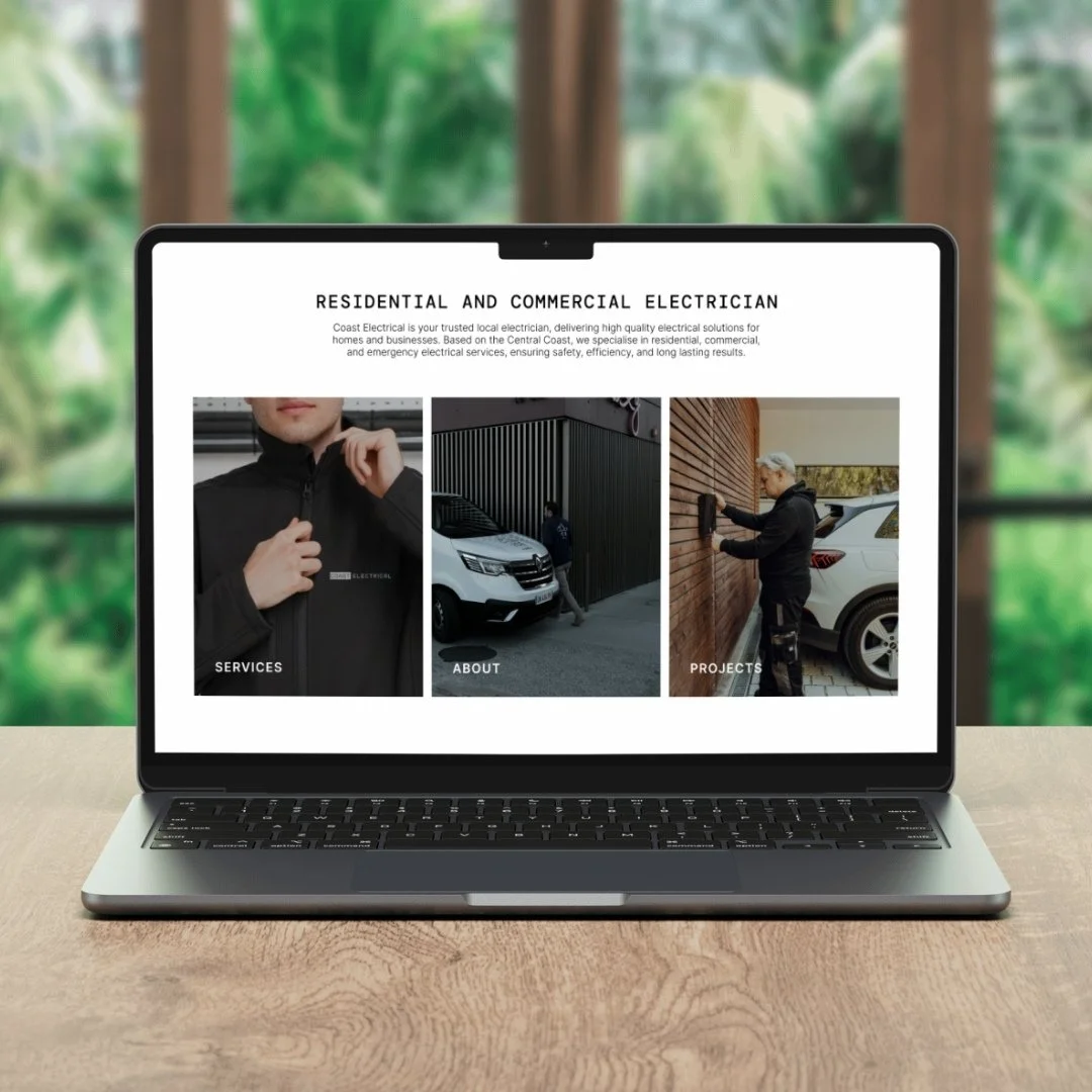 Laptop displaying a website for electrical services with images of people installing electrical systems outside a building.