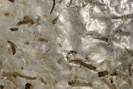 Close-up of a metallic surface with scratches, rust, and dirt.