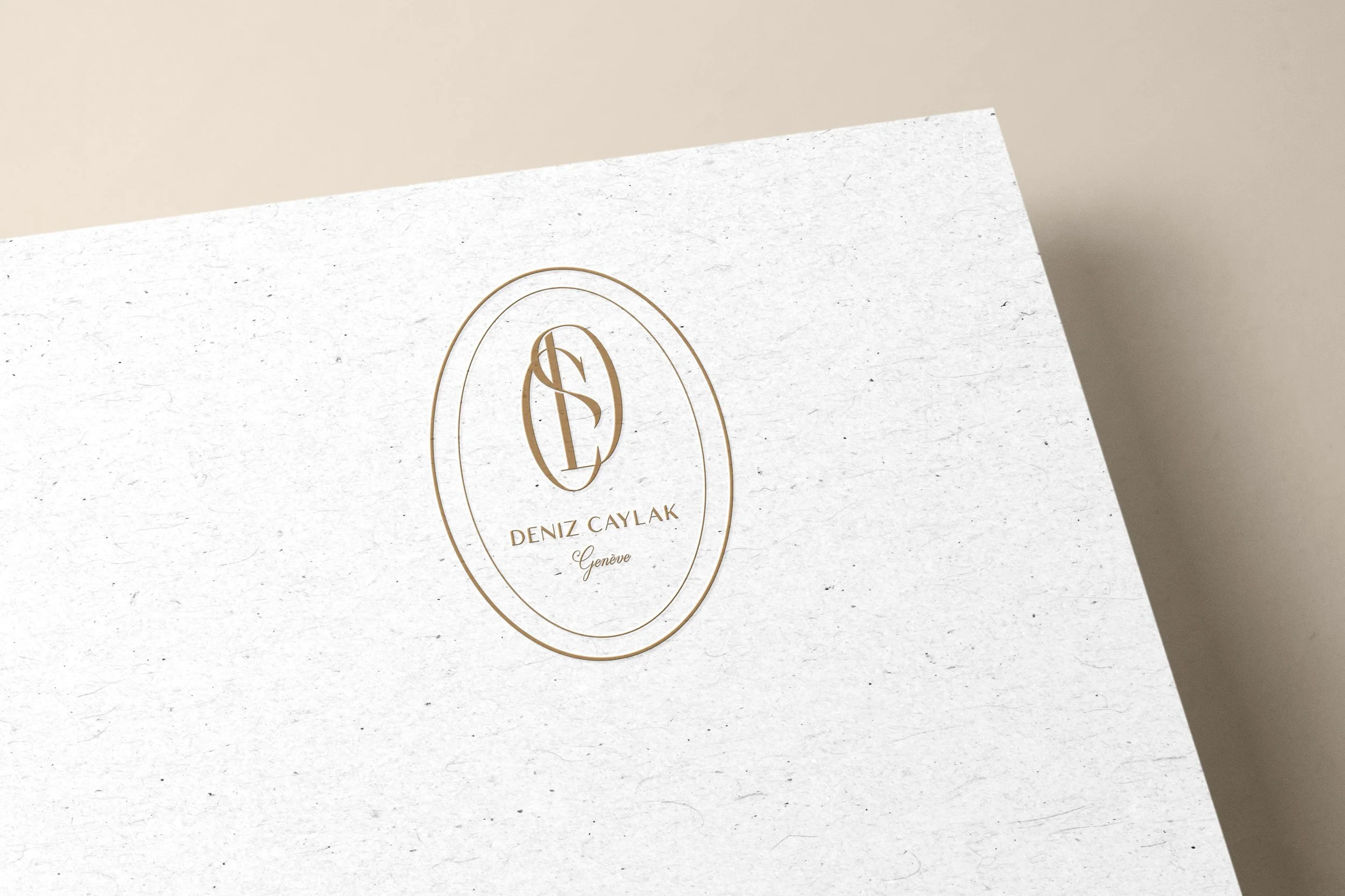 Carte de visite élégante avec un logo en or représentant les initiales 'D' et 'C', accompagnée du nom 'Deniz Caylak' et 'Genève' en écriture cursive.